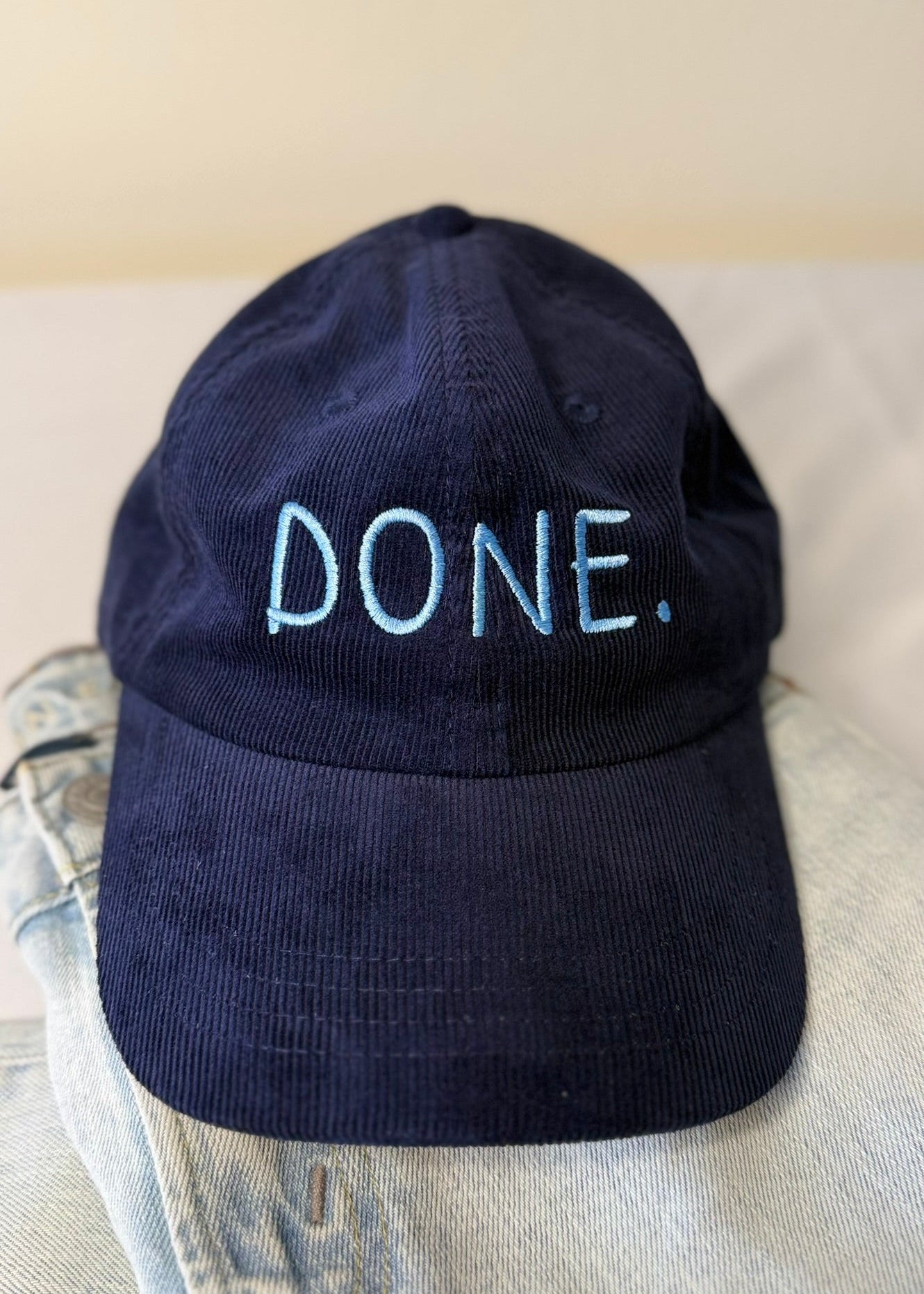 Navy blue cap with 'DONE.' text on a light background